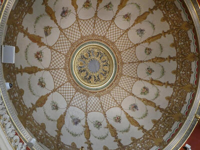 Circular ceiling with floral design and gold geometric design in center