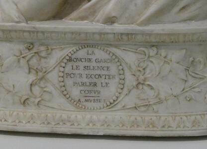 Inscription at base of bust: La bouche garde le silence pour ecouter parler le coeur - A. Musset