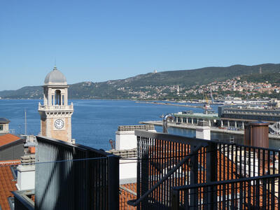 View of Trieste harbor from top floor of museum. A clock tower is in the left foreground