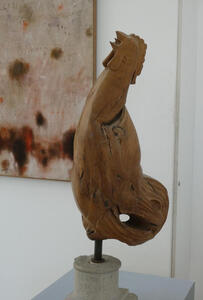 Carved wooden rooster, head tilted back, crowing