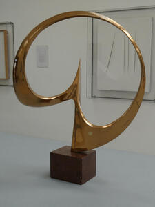 Brass circular sculpture with point at the place where the loop is joined