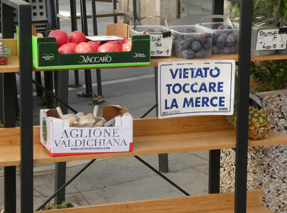 Boxes of fruits and vegetables. Sign: VIETATO TOCCARE LA MERCE