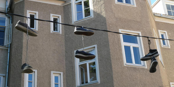 Three pairs of sneakers hanging over a line