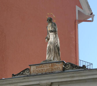 Statue of a person with a halo holding a cross