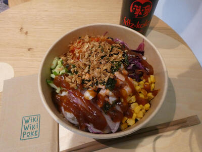 Poke bowl with shrimp, corn, red cabbage, cucumber, and other toppings