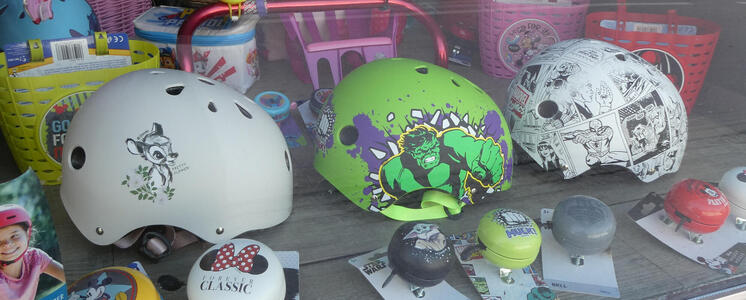 Children’s bicycle helmets decorated with (from left to right) Bambi, The Incredible Hulk, and SpiderMan comic strip