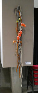 White, gray, and orange ropes. On the rope are some orange flowers.