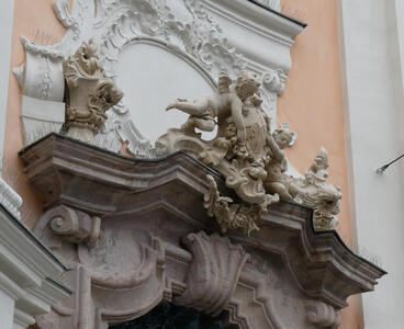 Lintel above doorway with ornate scrollwork and cherubs
