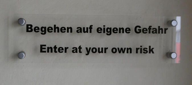 Text in German and English: Begehen auf eigene Gefahr / Enter at your own risk