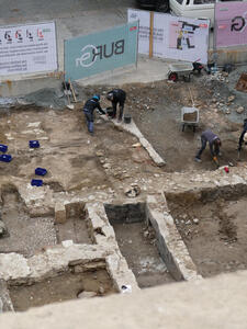 Workers who appear to be excavating the foundation of an older building