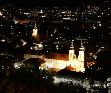 Nighttime view of Graz from Schloßberg; several churches are illuminated.