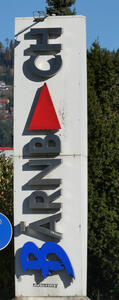 Bärnbach written vertically bottom to top (rotated 90 degrees counterclockwise). The second A is a red arrow poiting upwards.