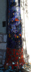 Pillar covered with blue and red irregularly shaped mosaic tiles