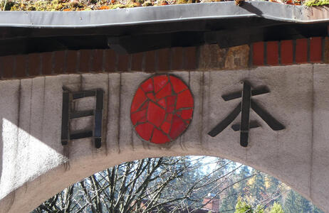 Japanese Kanji for “nihon“; between the two symbols is a mosaic red sun.