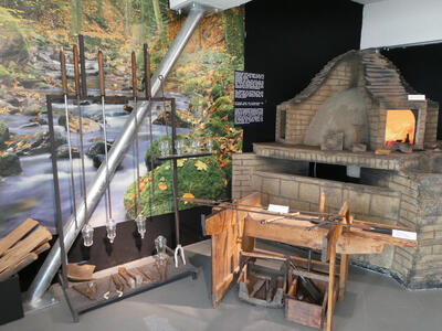 Re-creation of a workshop showing oven, tools, and some blown glass.