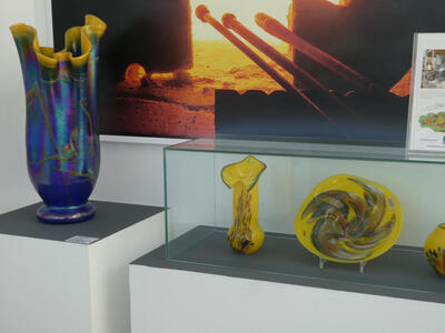 At left, a fluted blue vase; at right, yellow fluted vase and dish