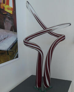 Glass sculpture with intersecting tubes of black and clear striped glass