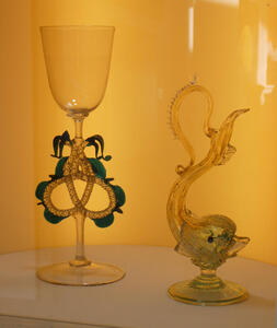 At left, a wine glass with a trefoil shaped stem; at right, a fish