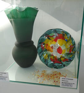 At left, green fluted-top vase. At right, a sphere with multi-colored patches in it.