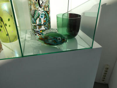 Green glass fish. At its right, a transparent green glass