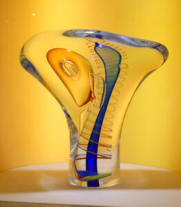 Abstract glass sculpture with a red helix around a central blue portion.