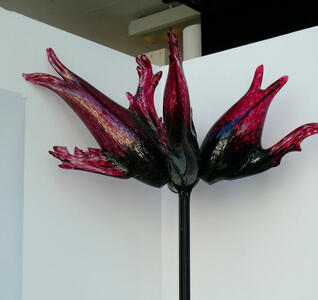 Top section of floor lamp. The top has the shape of red flames projecting from the center.