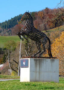 Metal sculpture of horse rearing up on hind legs. The sculpture is made from horseshoes.