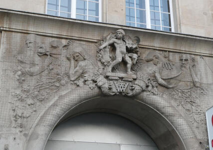 Carving above archway showing an angel surrounded by holy figures.