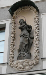 Woman with hands clasped in prayer. Above her head, a halo of stars.