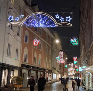 Various Christmas decorations hanging above a street.