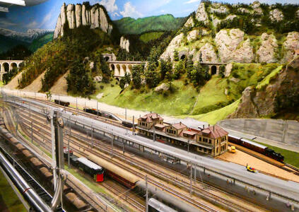 Model railway; bridges and mountains in background, tracks and small station in foreground