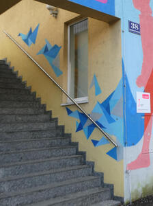 Wall painting of blue origami cranes “flying”