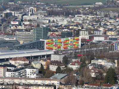 City view. In center, a building with red, orange, yellow, and green balconies