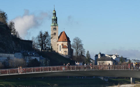 Bridge in foreground; in background, an old church with a green spire.