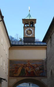 Church clock tower in background; beneath it, a painting of Christ taken down from cross