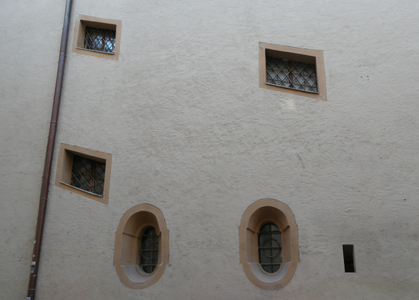 Three parallelogram windows and two oval windows beneath.