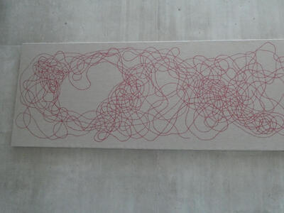 Cloth canvas with what appears at a distance to be a mass of squiggly red lines.