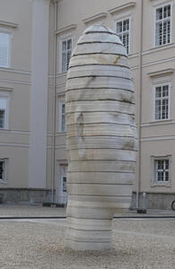 Large sculpture of woman’s head made up of vertically stacked layers of stone
