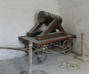 Ancient weapon that looks like a barrel. It is mounted on a cart with wheels.