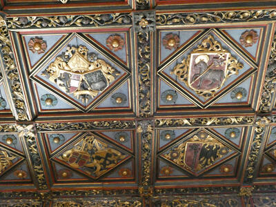 Colorful heraldic shields that tile a ceiling