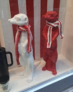 Red and white meerkat figurines wearing red and white scarves