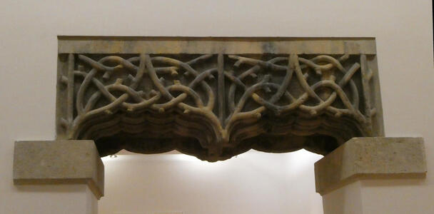 Stone carving above doorway with intricate intertwined “ropes”