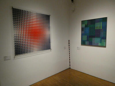 Two “op-art” style paintings. One has red and blue squares; the other, green and blue squares of various shades.