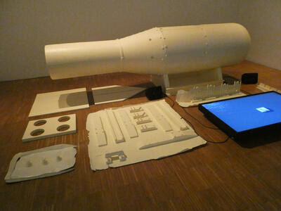 Model of the small Hiroshima bomb; showing some of the internal parts separate from the main body of the bomb