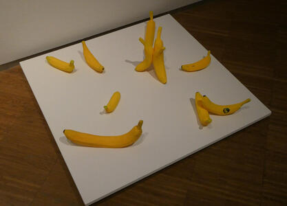 Models of bananas scattered about on a square platform.