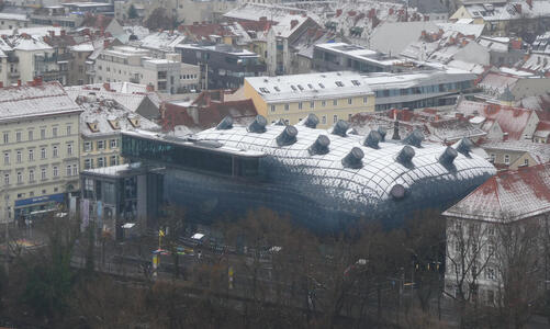 View of Kunsthaus from Uhrturm; the museum has a light covering of snow on the roof.