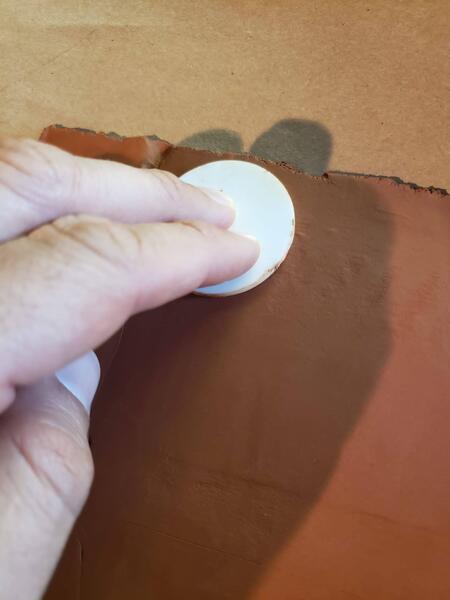 index and middle fingers pressing mold into clay