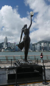 Statue of woman holding a large pearl above her head.