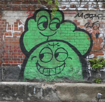 Graffiti of a green cloud above a green semicircle. The cloud is simling sweetly; the semicircle is grinning