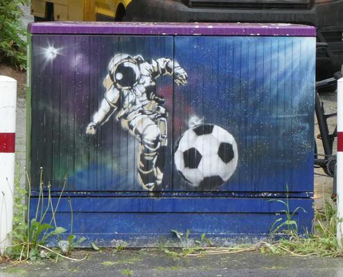 Utility box showing man in spacesuit in outer space kicking soccer ball.